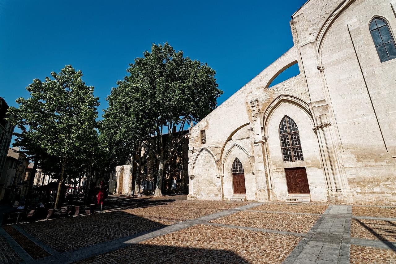 Troupe de théâtre de rue se produisant sur une place d'Avignon devant un public